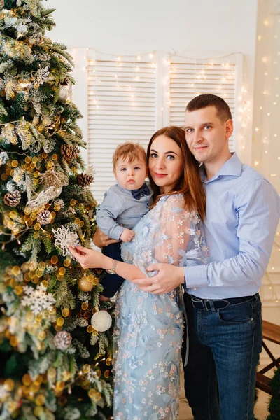 幸せと美しいお母さんお父さんと小さな息子はクリスマスツリーを飾る. — ストック写真