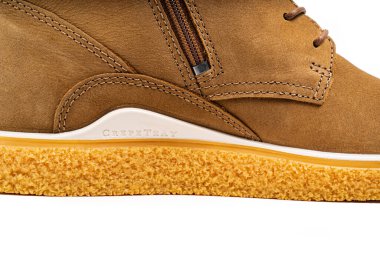 Kahverengi deri bir botun parçası. Beyaz arka planda bağcıkları var.