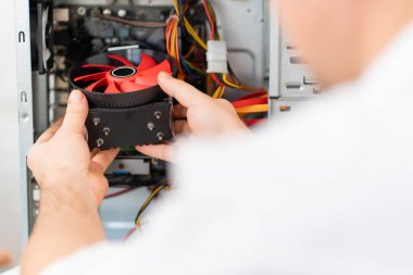 Bilgisayar atölyesi. Tamircinin eli bilgisayara soğutucu yerleştirir