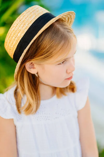 Печальный портрет маленькой девочки с светлыми волосами в соломенной шляпе. Детские капризы — стоковое фото