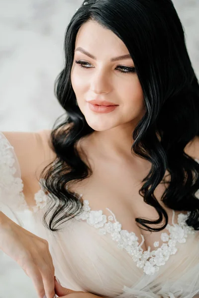Primer plano. hermosa novia morena en vestido blanco. cabello y maquillaje para novia. — Foto de Stock
