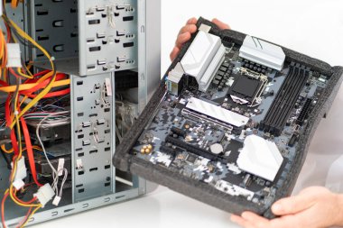 Bir adamın eli atölyedeki bilgisayarı tamir eder. Arkadan görünüm