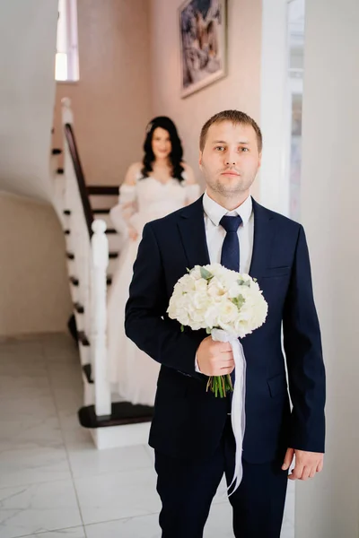 新郎站在楼梯旁边等新娘下来. — 图库照片