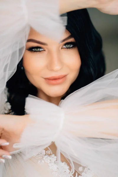 Close-up. beautiful brunette bride in white dress with transparent puffy sleeves — Fotografia de Stock