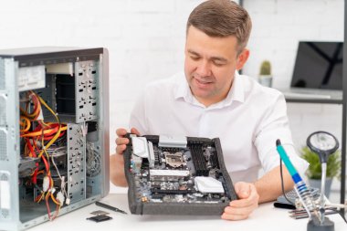 Bilgisayar tamircisi. Profesyonel hizmet. Bir adam ana kartı tamir eder.