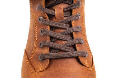 Üst Manzara. Kahverengi deri botların beyaz arka planda bağcıkları var.