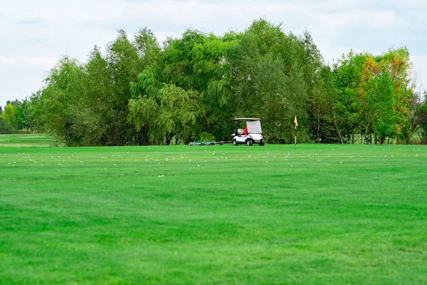 Paisagem. carro elétrico no campo de golfe e céu com nuvens. relva grama. — Fotografia de Stock