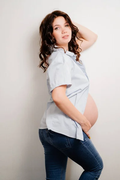 Donna incinta in jeans e camicia. salute delle donne — Foto Stock