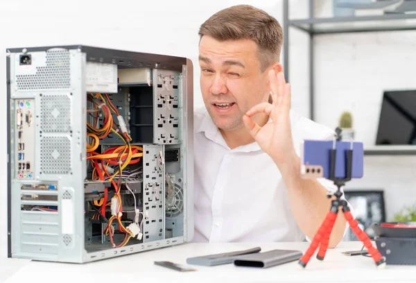 A man records a video lesson on computer repair or makes an online consultation. — Stock Photo, Image