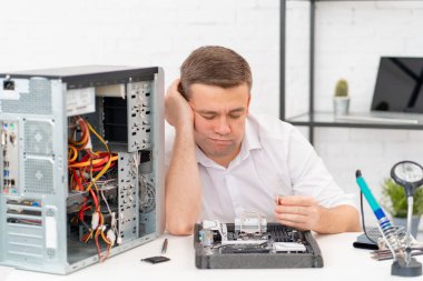 Bilgisayar atölyesi. Profesyonel hizmet. Elinde işlemci olan üzgün bir tamirci.