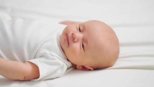 Schattige baby op een wit laken. gezondheid en goede voeding van kinderen. — Stockvideo