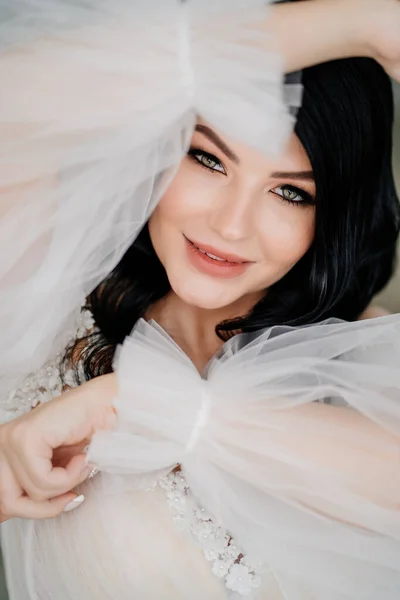 Nahaufnahme. schöne brünette Braut im weißen Kleid mit transparenten geschwollenen Ärmeln — Stockfoto