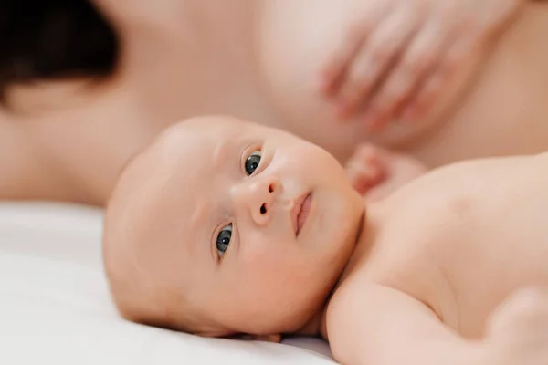 Кормление грудью. ребенок лежит рядом с матерью после кормления — стоковое фото