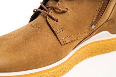 Kahverengi deri bir botun parçası. Beyaz arka planda bağcıkları var.