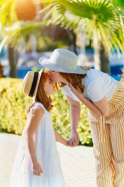 Мама и дочь в шляпах в тропическом парке отеля — стоковое фото