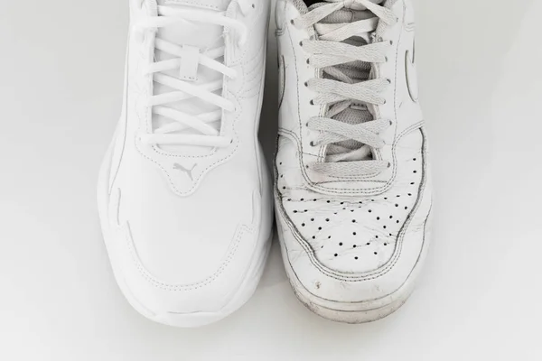 Puma i Nike. stare i nowe białe trampki z sznurowadłami na białym tle. — Zdjęcie stockowe