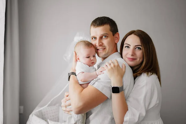 A happy family with a newborn baby at home near the cot. mom, dad and baby. — Φωτογραφία Αρχείου