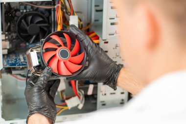 Arkadan bak. Bilgisayar atölyesi. Tamirci bilgisayara soğutucu yükler