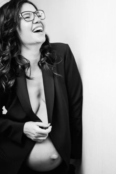 Heureuse femme enceinte dans des lunettes et veste noire avec seins nus et ventre — Photo