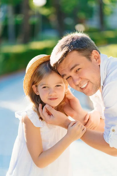 Dad gently and lovingly holds his daughters face with his hands. — Stock Photo, Image