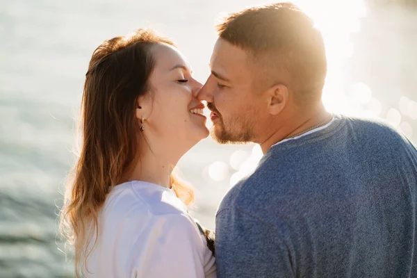 Verliebte Paare küssen sich am Strand des Meeres. Sonneneinstrahlung — Stockfoto