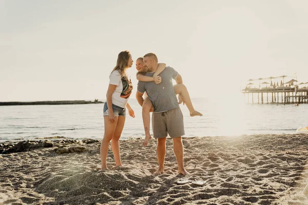 Happy family. Dad rides daughter on back on the seashore. — Foto Stock