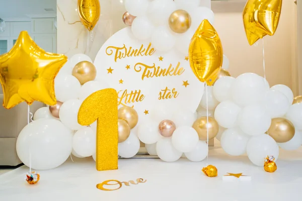 En fotozon för den första födelsedagen av vita och guld ballonger och en siffra ett — Stockfoto