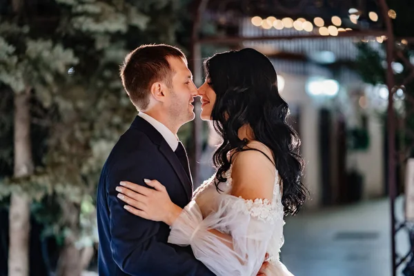 Gentle and happy bride and groom in wedding dresses on the evening street. — Stockfoto