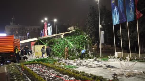 A munkások szétszednek egy nagy mesterséges karácsonyfát a város utcáján.. — Stock videók