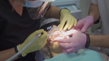 Gerçek. Dişçi hastaların dişlerini fırçalar. düzenli bakım ve önleme.