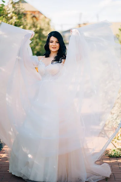 Bela noiva em vestido de noiva no parque. tecido transparente fino para vestido. — Fotografia de Stock