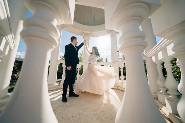 Noiva e noivo em roupas de casamento dançar em gazebos ou rotunda no parque. — Fotografia de Stock