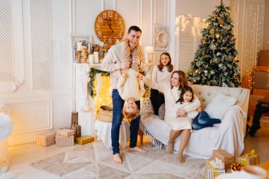 Noel ağacının yanındaki bir odada büyük, güzel ve mutlu bir aile..