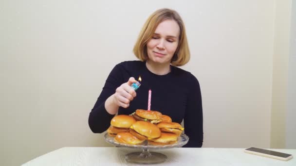 Kobieta zapala świece i wypowiada życzenie na hamburgerowym torcie. oryginalny tort. — Wideo stockowe