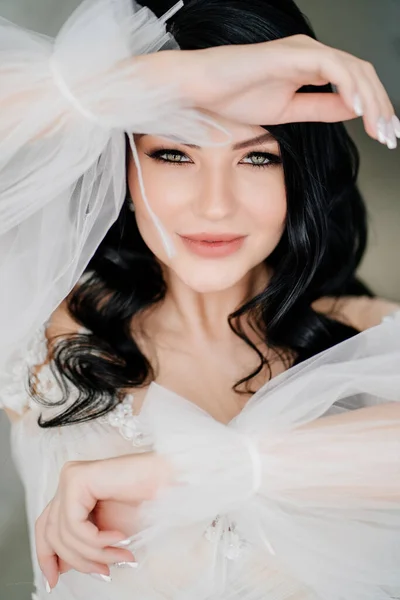 Primer plano. hermosa novia morena en vestido blanco con mangas hinchadas transparentes — Foto de Stock