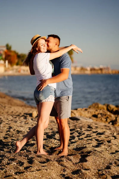 Homem e mulher no amor abraço e beijo na praia. recém-casados no resort. sol brilhante. — Fotografia de Stock