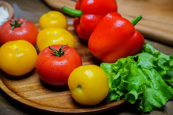 Alface, tomates amarelos e vermelhos e pimentão com gotas de água. pepinos. — Fotografia de Stock