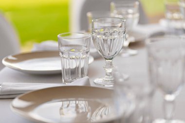 Şenlik masasına servis. Masanın üzerinde boş beyaz bir tabak ve bardaklar.. 