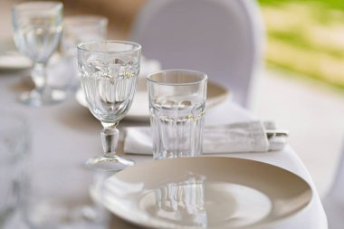 Şenlik masasına servis. Masanın üzerinde boş beyaz bir tabak ve bardaklar.. 
