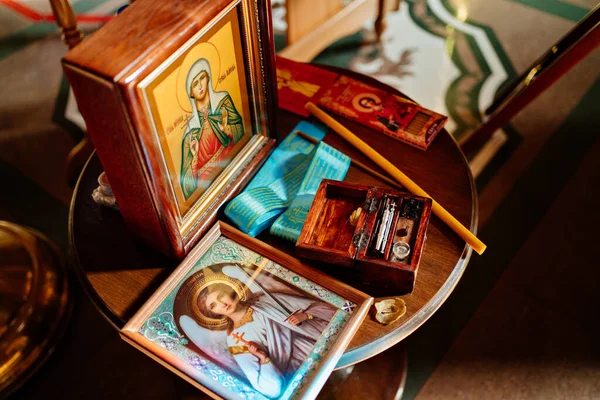 Iconos y bautismales puestos sobre la mesa en la Iglesia Ortodoxa. — Foto de Stock