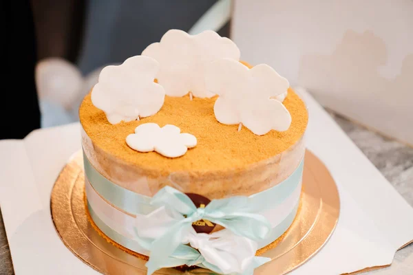 En liten tårta dekorerad med band och sockermoln — Stockfoto