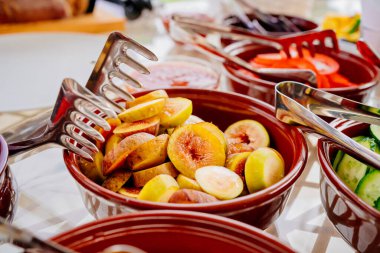 Masanın üzerinde doğranmış sebzeler ve meyveler var.. 