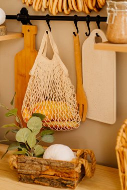 Bir somun ekmek, bir kesim tahtası ve mutfakta asılı duran bir spatula.