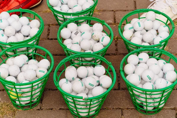 Πράσινα καλάθια με μπάλες του γκολφ. αξεσουάρ για το παιχνίδι. — Φωτογραφία Αρχείου