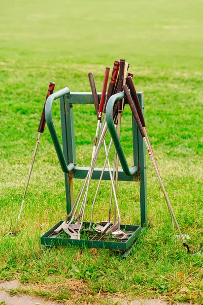 Μπαστούνια του γκολφ σε ένα περίπτερο στο γκαζόν. αξεσουάρ για το παιχνίδι. — Φωτογραφία Αρχείου