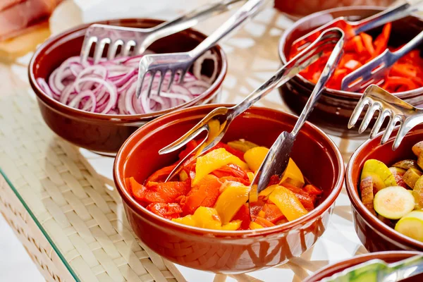 Миски с нарезанными овощами и фруктами на столе. — стоковое фото