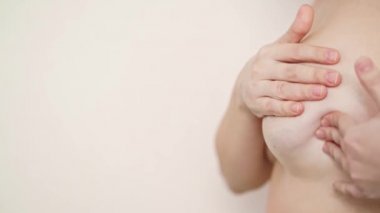 Bir kadın emzirme sırasında meme masajı yapar. Kendi kendine teşhis koyuyor. Boşluğu kopyala.