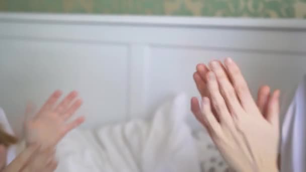 Anne ve kızının elleri yatak odasındaki yatakta avuç içi oynuyor.. — Stok video