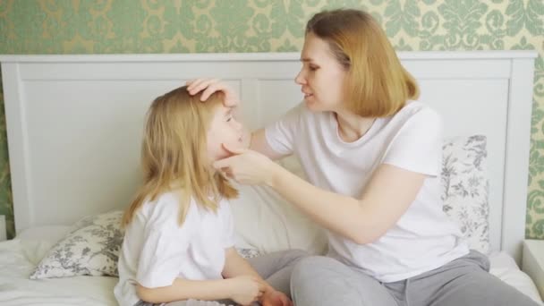 Dochter klaagt over een spleet of pijn in het oog en moeder onderzoekt haar. — Stockvideo