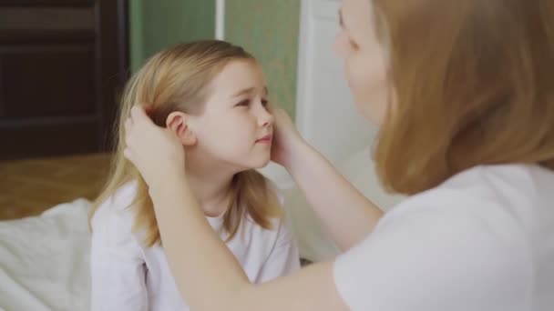 Dcera si stěžuje na bolest v uchu a matka ji zkoumá. — Stock video